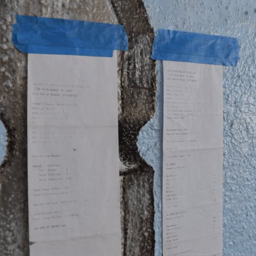 Poll tapes posted in public view on the wall of a polling place on election night