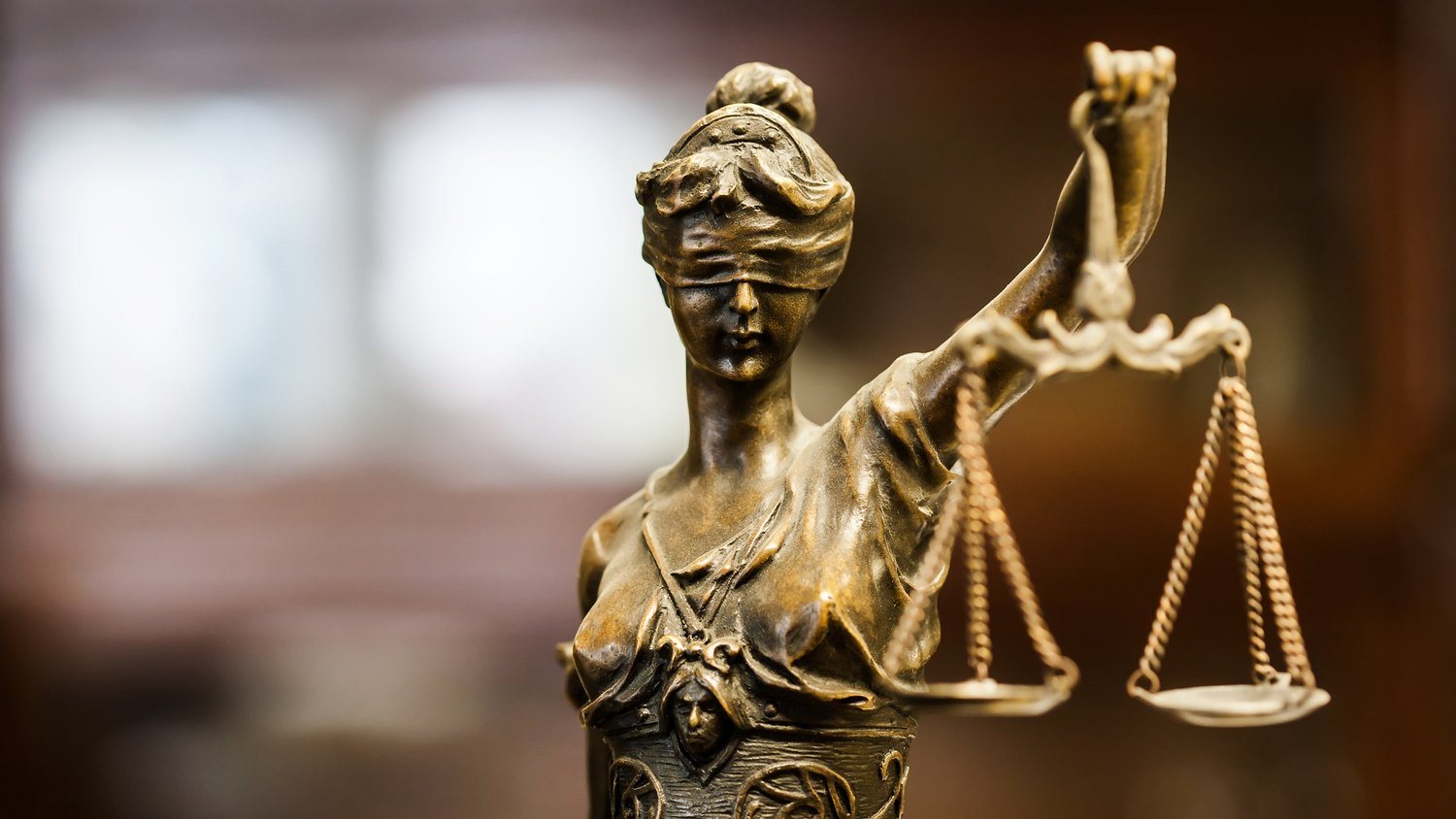 The Lady Justice statue, blindfolded, holding up a set of balance scales